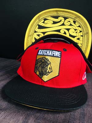 The Katchafire X Calibis Snapback Cap is a custom designed cap, with a gold maori designed print on the underside of peak.  Shield emblem embroidered.
